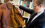Thomas Venning examines Albert Einstein's leather jacket ahead of an auction in which the clothing item will be sold. (Courtesy Christie's)