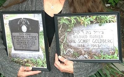 Danette Devlin holding photos of the gravestones of her great-grandparents Herman and Cyril Schiff, attesting to her Jewish roots. (Courtesy of Danette Devlin/via JTA)