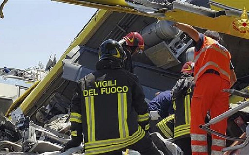 Italian firefighters inspect the wreckage of two commuter trains after their head-on collision in the southern region of Puglia, killing at least 20 people, on July 12, 2016. (Italian Firefighter Press Office via AP)