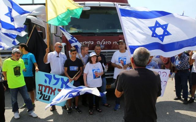 The parents of late Israeli soldier Oron Shaul block trucks heading to the Gaza Strip at the Erez Crossing, July 3, 2016. (Flash90) The parents of late Israeli soldier Oron Shaul block trucks heading to the Gaza Strip at the Erez Crossing, July 3, 2016. (Flash90)