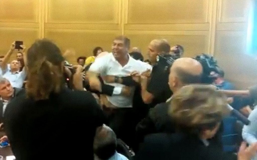 An employee of the Israel Broadcasting Authority is forcibly removed from a stormy meeting on its closure at the Knesset Economics Affairs committee on July 24, 2016 (screen capture: YouTube)