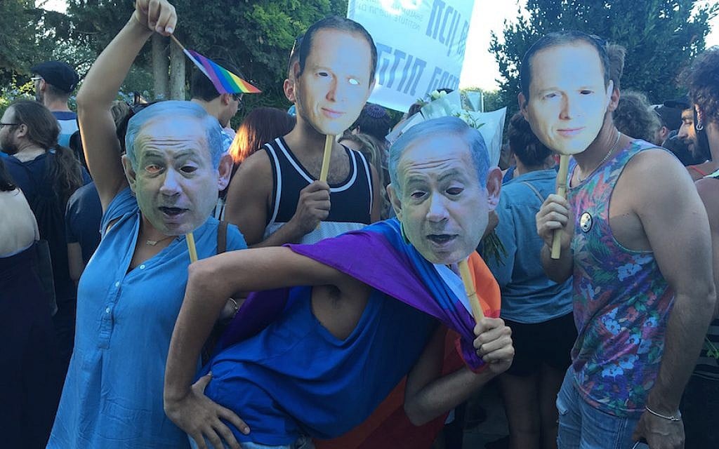 Liron Shimonie, far left, and Yuval Regev, center, wearing masks of Israeli Prime Minister Benjamin Netanyahu’s face at the Jerusalem Pride Parade, July 21, 2016. (Andrew Tobin) Liron Shimonie, far left, and Yuval Regev, center, wearing masks of Israeli Prime Minister Benjamin Netanyahu’s face at the Jerusalem Pride Parade, July 21, 2016. (Andrew Tobin)