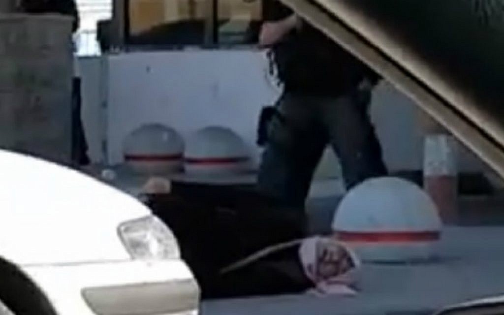 A still image taken from a footage filmed at the scene apparently shows a Palestinian woman lying on the ground after she is shot by security guards at the Qalandiya checkpoint between Ramallah and Jerusalem on July 26, 2016 (screen capture: YouTube)