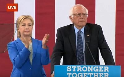 Hillary Clinton looks on as Bernie Sanders endorses her for US president, at a rally in New Hampshire on July 12, 2016 (screen capture: YouTube)
