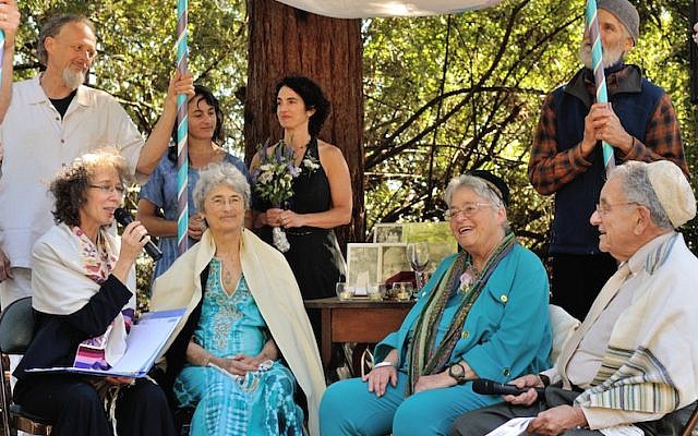 At 76, longtime activists Shoshana Dembitz, seated, center left, and Abigail Grafton, seated, center right, married in El Cerrito, Calif., on June 27. The ceremony was officiated by Rabbi Diane Elliot, seated left, and her husband, Rabbi Burt Jacobson. (Lea Delson via JTA)