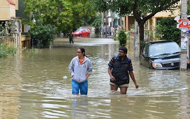 Residents wade through knee deep water in a low lying flooded area of Bangalore, India, July 29, 2016 (AFP/MANJUNATH KIRAN)