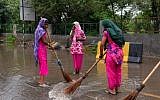 Indian municipal cooperation workers clear water from a main road in Gurgaon on the outskirts of New Delhi, India, July 30, 2016. (AFP/CHANDAN KHANNA)