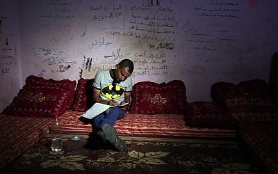Palestinian singer Adel Meshoukhi writing at his home in Rafah in the southern Gaza Strip, July 29, 2016. (AFP /SAID KHATIB)