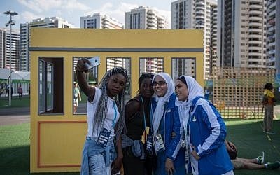 Members of Iran's Olympic team pose for selfies with two performers prior to a welcoming ceremony held at the athletes village of the Rio 2016 Olympic Games on August 1, 2016. (AFP PHOTO/ED JONES)