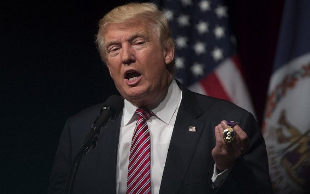 Republican presidential nominee Donald Trump holds a purple heart medal given to him by Lt. Col. Louis Dorfman during a campaign event at Briar Woods High School August 2, 2016, in Ashburn, Virginia. (AFP PHOTO/MOLLY RILEY)