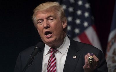 Republican presidential nominee Donald Trump holds a purple heart medal given to him by Lt. Col. Louis Dorfman during a campaign event at Briar Woods High School August 2, 2016, in Ashburn, Virginia. (AFP PHOTO / MOLLY RILEY)