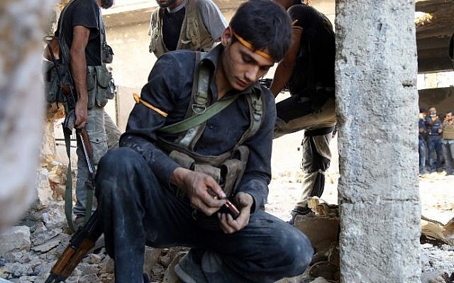 A rebel fighter reloads the magazine of his weapon during clashes with regime forces in Ramussa on the southwestern edges of Syria's northern city of Aleppo on August 6, 2016. (AFP PHOTO / FADI AL-HALABI)