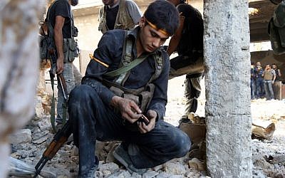A rebel fighter reloads the magazine of his weapon during clashes with regime forces  in Ramussa on the southwestern edges of Syria's northern city of Aleppo on August 6, 2016. (AFP PHOTO/FADI AL-HALABI)