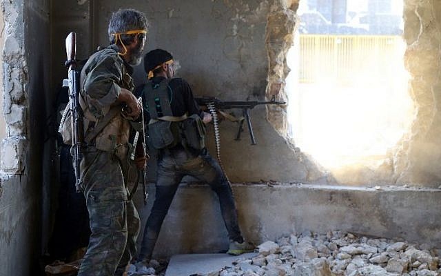 Rebel fighters fire towards positions of regime forces in Ramussa on the southwestern edges of Syria's northern city of Aleppo on August 6, 2016. (AFP PHOTO / FADI AL-HALABI)