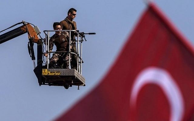 Turkish special force police officers stand guard as people wave Turkish national flags during a rally against failed military coup, in Istanbul, August 7, 2016. (AFP/OZAN KOSE) Turkish special force police officers stand guard as people wave Turkish national flags during a rally against failed military coup, in Istanbul, August 7, 2016. (AFP/OZAN KOSE)