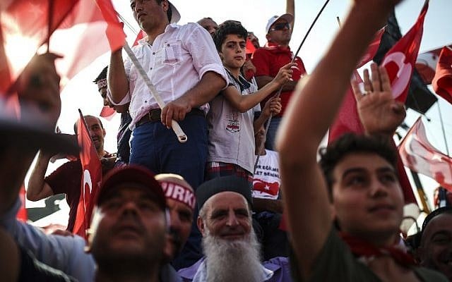 Demonstrators wave Turkish national flags as they stand in front of giant screens during a rally against failed military coup,in Istanbul, August 7, 2016. (AFP/BULENT KILIC) Demonstrators wave Turkish national flags as they stand in front of giant screens during a rally against failed military coup,in Istanbul, August 7, 2016. (AFP/BULENT KILIC)