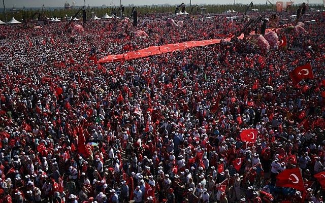 File: Demonstrators wave Turkish national flags and hold a giant banner with Turkish national flags as they stand in front of giant screens next to balloons in the color of the Turkish national flag during a rally against failed military coup, in Istanbul, August 7, 2016. (AFP/BULENT KILIC) File: Demonstrators wave Turkish national flags and hold a giant banner with Turkish national flags as they stand in front of giant screens next to balloons in the color of the Turkish national flag during a rally against failed military coup, in Istanbul, August 7, 2016. (AFP/BULENT KILIC)