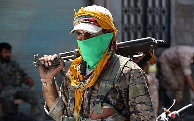 A member of the Syrian Democratic Forces (SDF) walks on a street with his weapon in the northern Syrian town of Manbij on August 7, 2016, as SDF comb the city in search of the last remaining jihadists, a day after they retook it from the Islamic State group. (AFP PHOTO/DELIL SOULEIMAN)