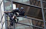 Police grab an unidentified man scaling Trump Tower using suction cups on August 10, 2016 in New York. (AFP/ Bryan R. Smith)