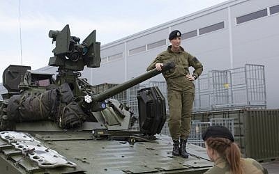 Female soldiers talk next to a CV90 combat vehicle at the armored battalion in Setermoen, northern Norway on August 11, 2016. (AFP PHOTO/KYRRE LIEN) 