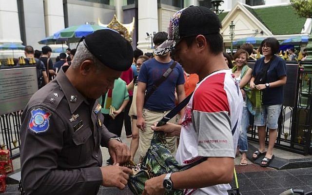 File: A Thai policeman searches a visitor's bag in the center of Bangkok, Thailand, August 13, 2016. (AFP/Munir Uz Zaman) File: A Thai policeman searches a visitor's bag in the center of Bangkok, Thailand, August 13, 2016. (AFP/Munir Uz Zaman)