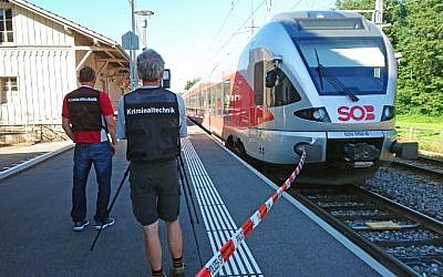 Policemen stand by a train at the station in Salez, eastern Switzerland, after a man set a fire and stabbed passengers on August 13, 2016. (AFP PHOTO / newspictures.ch / Beat KAELIN)