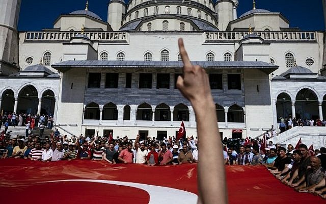 This file photo taken on July 17, 2016 shows pro-Erdogan supporters holding a giant Turkish flag during funerals of the victims of the coup attempt at Kocatepe Mosque in Ankara. (AFP PHOTO / DIMITAR DILKOFF) This file photo taken on July 17, 2016 shows pro-Erdogan supporters holding a giant Turkish flag during funerals of the victims of the coup attempt at Kocatepe Mosque in Ankara. (AFP PHOTO / DIMITAR DILKOFF)