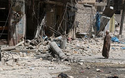 A resident of the Tariq al-Bab neighborhood of Aleppo, inspects the damage caused by reported air raids that targeted rebel-held areas in the northern city on August 16, 2016. (AFP PHOTO/THAER MOHAMMED)