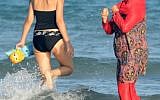 Illustrative: Women, one, wearing a 'burkini,' a full-body swimsuit designed for Muslim women, walk in the water on Ghar El Melh beach near Bizerte, north-east of the capital Tunis, August 16, 2016.  (AFP/FETHI BELAID)
