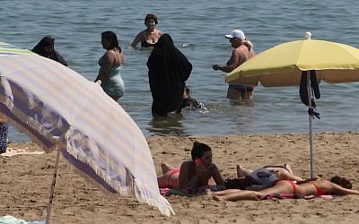Illustrative: 2 Muslim women wearing a chador as they enjoy their time with other people  a beach of Narbne, southern France, June 4, 2015. (AFP/Raymond ROIG)