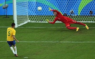 Renato Augusto puts a goal past Germany's goalkeeper Timo Horn during the penalty shoot-out of the Rio 2016 Olympic Games men's football gold medal match between Brazil and Germany at the Maracana stadium in Rio de Janeiro on August 20, 2016. (AFP PHOTO / Johannes EISELE)