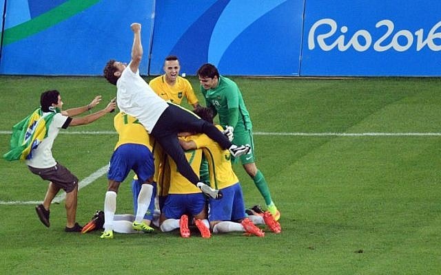 Brazil's players celbrate after winning the penalty shoot-out of the Rio 2016 Olympic Games men's football gold medal match between Brazil and Germany at the Maracana stadium in Rio de Janeiro on August 20, 2016. AFP/ Johannes EISELE)