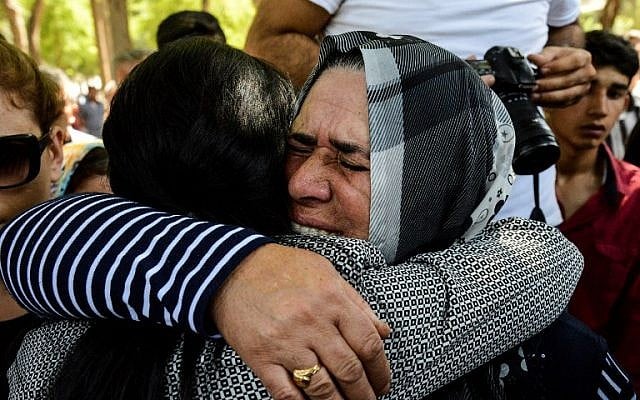 A woman is comforted during a funeral for a victim of last night's attack on a wedding party that left 50 dead in Gaziantep in southeastern Turkey near the Syrian border on August 21, 2016. (AFP PHOTO / ILYAS AKENGIN)