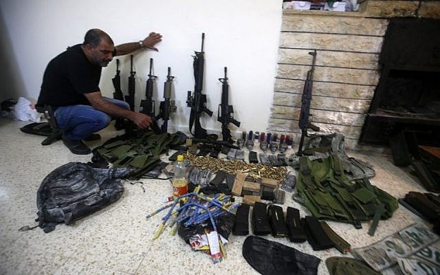 A member of the Palestinian security forces displays weapons at a police station in the West Bank city of Nablus , that the police found on search operation for gunmen who are on the run, August 21, 2016. (AFP/JAAFAR ASHTIYEH) A member of the Palestinian security forces displays weapons at a police station in the West Bank city of Nablus , that the police found on search operation for gunmen who are on the run, August 21, 2016. (AFP/JAAFAR ASHTIYEH)