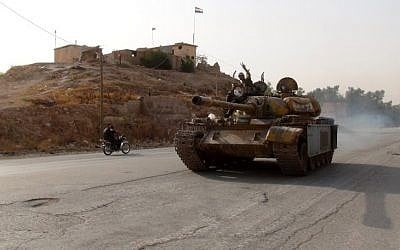 A pro-regime fighter flashes the sign of victory on August 21, 2016 as he drives a tank in the southern district of Ghweiran in the Syrian northeastern city of Hasakeh, where Kurdish forces were advancing (AFP/STR)