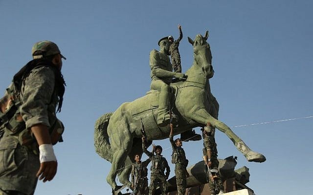 Kurdish fighters belonging to the police force -- the Asayesh -- and the People's Protection Units (YPG) stand on a statue of Basel Assad, the late elder brother of the Syrian President, in the northeastern Syrian city of Hasakeh on August 23, 2016, after they agreed to a truce with regime forces. (AFP PHOTO/DELIL SOULEIMAN) Kurdish fighters belonging to the police force -- the Asayesh -- and the People's Protection Units (YPG) stand on a statue of Basel Assad, the late elder brother of the Syrian President, in the northeastern Syrian city of Hasakeh on August 23, 2016, after they agreed to a truce with regime forces. (AFP PHOTO/DELIL SOULEIMAN)
