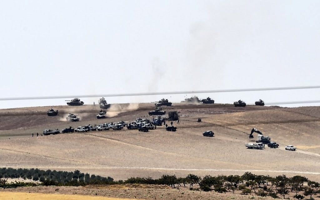 An image taken taken along Turkey's border city of Karkamis on August 24, 2016 shows Turkish army tanks and pro-Ankara Syrian opposition fighters moving two kilometers west from the Syrian town of Jarabulus. (AFP PHOTO/BULENT KILIC)