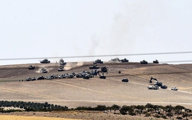 An image taken taken along Turkey's border city of Karkamis on August 24, 2016 shows Turkish army tanks and pro-Ankara Syrian opposition fighters moving two kilometers west from the Syrian town of Jarabulus. (AFP PHOTO/BULENT KILIC)