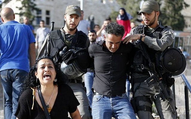 A woman reacts as Israeli border policemen arrest a Palestinian protester, who did not follow their instruction to leave, during a demonstration against administrative detention on August 24, 2016 at Damascus Gate in Jerusalem. AFP/ AHMAD GHARABLI)