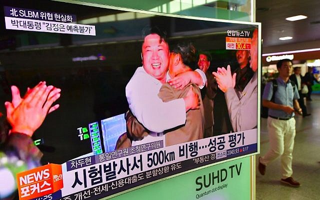 A man walks past a television screen showing North Korean leader Kim Jong-Un celebrating its latest submarine-launched ballistic missile test at a railway station in Seoul, August 25, 2016. (AFP/JUNG YEON-JE)