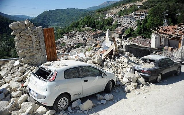 Cars sit amidst the rubble from earthquake damaged buildings in the central Italian village of Pescara del Tronto on August 25,2016 a day after a magnitude of between 6.0 and 6.2. earthquake struck the region killing more than 200 people. (AFP PHOTO/MARCO ZEPPETELLA)