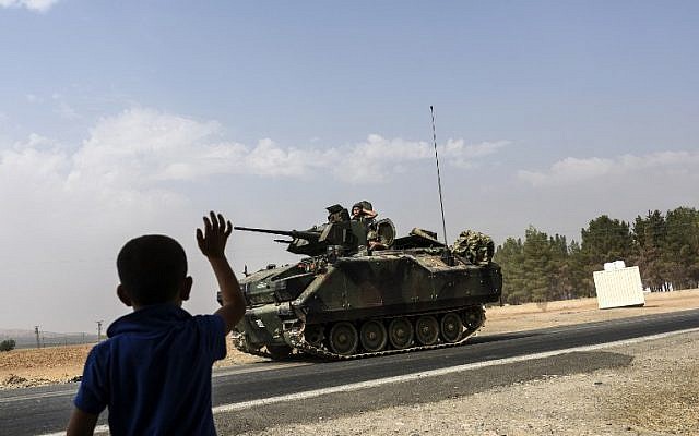 A Turkish boy waves to Turkish tank convoy driving into Syria from the Turkish Syrian border city of Karkamis in the southern region of Gaziantep, on August 26, 2016. AFP / BULENT KILIC) A Turkish boy waves to Turkish tank convoy driving into Syria from the Turkish Syrian border city of Karkamis in the southern region of Gaziantep, on August 26, 2016. AFP / BULENT KILIC)