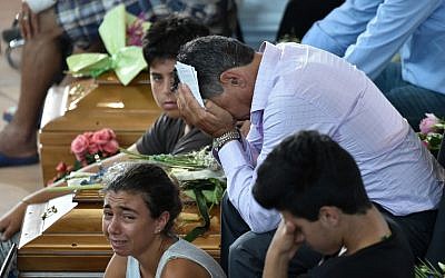 Relatives mourn next to a coffin during a funeral service for victims of the earthquake, at a gymnasium arranged in a chapel of rest on August 27, 2016, in Ascoli Piceno, three days after a 6.2-magnitude earthquake struck the region killing some 290 people. (AFP PHOTO/ALBERTO PIZZOLI)