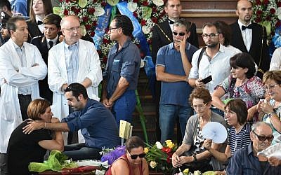 People attend a funeral service for victims of the Italian earthquake, at a gymnasium arranged in a chapel of rest on August 27, 2016, in Ascoli Piceno, three days after a 6.2-magnitude earthquake struck the region killing some 290 people. (AFP PHOTO/ALBERTO PIZZOLI)