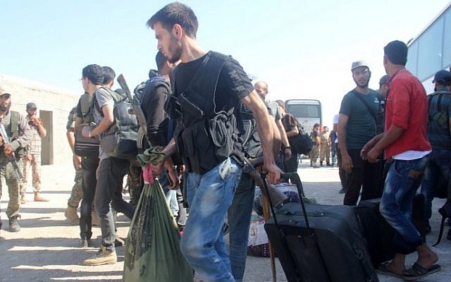Syrian rebel fighters and their families collect their bags from a bus on August 27, 2016 upon their arrival in the rebel-held northwestern city of Idlib after being evacuated from the town of Daraya. AFP/ Omar Haj Kadour) Syrian rebel fighters and their families collect their bags from a bus on August 27, 2016 upon their arrival in the rebel-held northwestern city of Idlib after being evacuated from the town of Daraya. AFP/ Omar Haj Kadour)