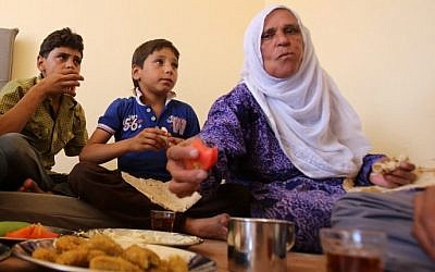A Syrian family, who has been evacuated from the town of Daraya, share a breakfast upon their arrival at a government reception center in the government-held town of Hrajela in Western Ghouta, outside Damascus, August 27, 2016. (AFP/Youssef KARWASHAN)