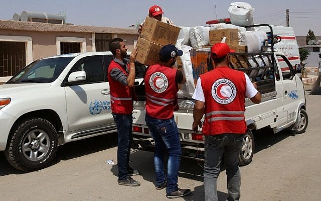 Members of the Syrian Arab Red Crescent (SARC) distribute food parcels at a government reception center in the government-held town of Hrajela in Western Ghouta, outside Damascus, upon the arrival of the families who have been evacuated from the town of Daraya, August 27, 2016. (AFP/Youssef KARWASHAN) Members of the Syrian Arab Red Crescent (SARC) distribute food parcels at a government reception center in the government-held town of Hrajela in Western Ghouta, outside Damascus, upon the arrival of the families who have been evacuated from the town of Daraya, August 27, 2016. (AFP/Youssef KARWASHAN)