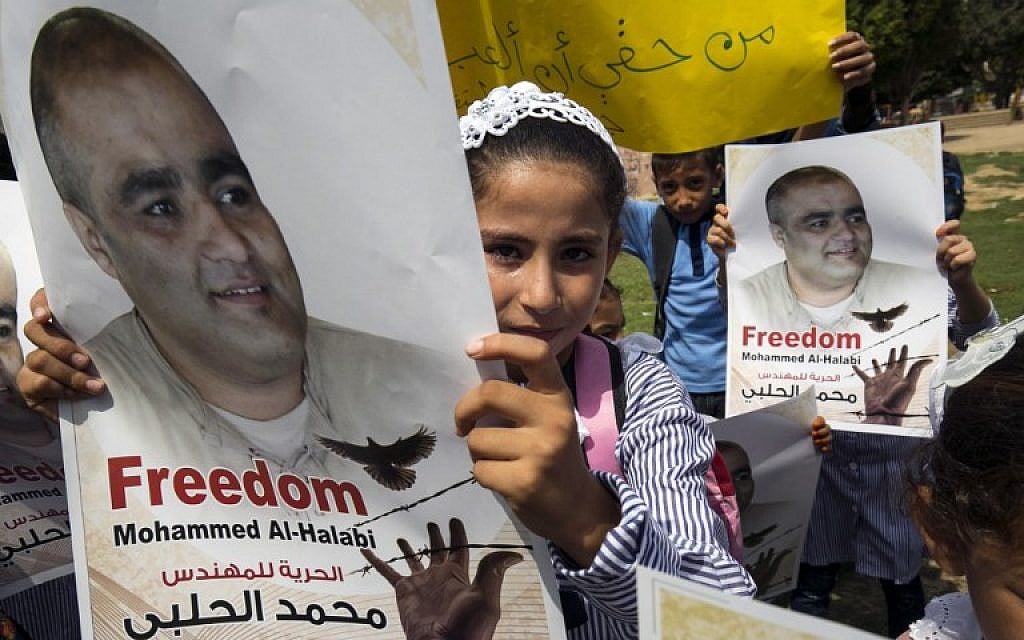 Palestinian children hold posters of Mohammed Halabi, the Gaza director of World Vision, a major US-based Christian NGO, during a protest to support him at Rafah town in the southern Gaza Strip on August 29, 2016. (AFP/ SAID KHATIB)
