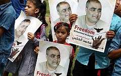 Palestinian children hold posters of Mohammed el-Halabi, the Gaza director of World Vision, a major US-based Christian NGO, during a protest to support him at Rafah town in the southern Gaza Strip August 29, 2016. (AFP/SAID KHATIB)