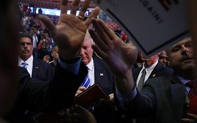 Republican presidential nominee Donald Trump autographs a campaign sign wjhSecret Service agents keep people back during a campaign event on August 10, 2016, in Fort Lauderdale, Florida (Joe Raedle/Getty Images/AFP)